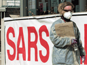 A nurse wearing protective gear walks outside a SARS in suburban Toronto, April 24, 2003.