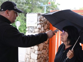An Israeli security guard measures the temperature of a woman at the entrance to a retirement home in the Ramat Efal district of Ramat Gan in Israel, on March 17, 2020.