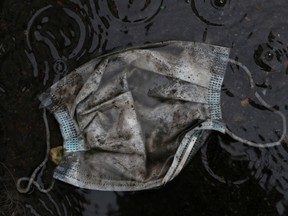A protective face mask is seen in the rain at a deserted street, during the coronavirus disease (COVID-19) outbreak in Madrid, Spain, March 31, 2020.