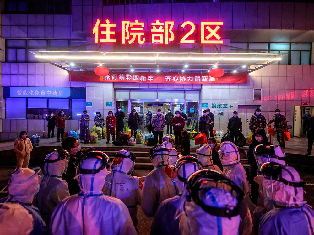 Patients infected by the COVID-19 coronavirus, at back,  wait to be transferred from Wuhan No.5 Hospital to Leishenshan Hospital, the newly-built hospital for COVID-19 patients, in Wuhan, China, on March 3, 2020. 