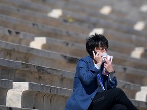 A man watches from an empty tribune during the Flame Handover Ceremony for the Tokyo 2020 Summer Olympics on March 19, 2020 in Athens, Greece. The ceremony was held behind closed doors as a preventive measure against the Coronavirus outbreak.