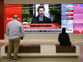 Prime Minister Justin Trudeau is seen on a screen in the financial district of Toronto, on Monday, March 16, 2020.