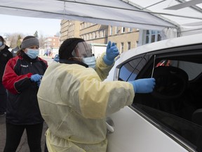 A medical worker prepares to swab a resident at a drive-through coronavirus testing facility at Sainte-Justine Children's Hospital in Montreal on March 21, 2020.