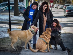 Virginia Champoux 
 and her daughters Nora-Jin Sokoloff, and Sarah-Qin Sokoloff walk their dogs in the Hampstead area of Montreal on March 16, 2020.