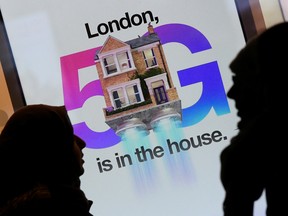 Pedestrians walk past an advertisement promoting the 5G data network at a mobile phone store in London, Britain, January 28, 2020.
