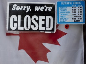 A 'Closed' sign hangs in a store window in Ottawa on April 16, 2020.