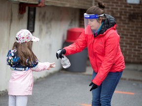 A student has her hands sanitized as schools outside the greater Montreal region begin to reopen their doors amid the COVID-19 outbreak, in Saint-Jean-sur-Richelieu, Quebec, May 11, 2020.