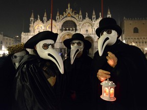 Masked revellers take part in the "Plague Doctors Procession" on Saint Mark Square in Venice on February 25, 2020, during the usual period of the Carnival festivities which have been cancelled following an outbreak of the COVID-19 novel coronavirus in northern Italy.