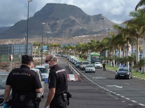 Spanish national police officers man a checkpoint at the entrance and exit of Arona, one of the most touristic municipalities in Tenerife on the Canary Islands, on April 13, 2020 amid a national lockdown to stop the spread of the COVID-19 coronavirus.