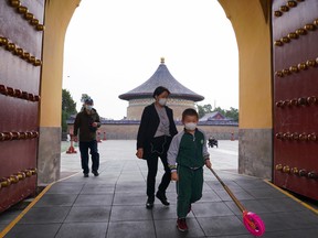 Chinese visitors wear protective masks as they tour the grounds of the Temple of Heaven on April 17, 2020 in Beijing, China.