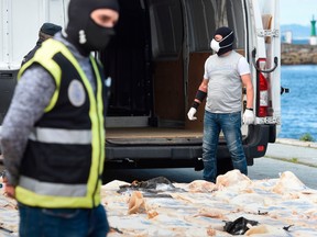 Spanish policemen check packs of cocaine in the port of Vigo, on April 28, 2020 after seizing the vessel MV Karar carrying 4000 kgs of cocaine, amid a national lockdown to fight the spread of the COVID-19 coronavirus.