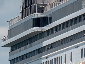 In this file photo passengers are seen onboard Holland America's cruise ship Zaandam as it entered the Panama City bay to be assisted by the Rotterdam cruise ship with supplies, personnel and COVID-19 testing devices, eight miles off the coast of Panama City, on March 27, 2020.