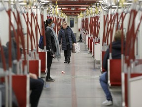 A passenger carries a pack of toilet paper on the subway during the evening commute in Toronto, Ontario, Canada, on Wednesday, March 25, 2020.