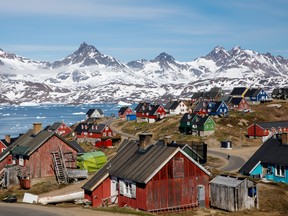 Snow covered mountains rise above the harbour and town of Tasiilaq, Greenland, June 15, 2018.