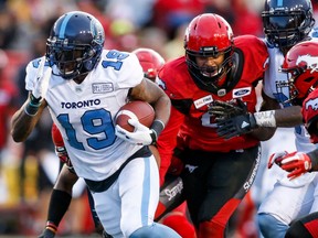 Toronto Argonauts' S.J. Green, left, makes it past Calgary Stampeders players during second half CFL football action in Calgary, Thursday, July 18, 2019.