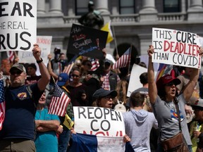 Demonstrators gather in front of the Colorado State Capitol building to protest coronavirus stay-at-home orders during a "ReOpen Colorado" rally in Denver, Colorado, on April 19, 2020.