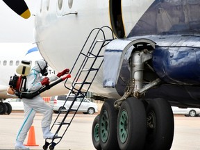 A member of a medical team wearing protective suit cleans the staircase to a plane at the airfield, to prevent the spread of the coronavirus disease (COVID-19), at the Juba International Airport in Juba, South Sudan April 5, 2020.
