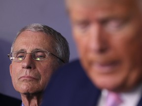 Dr. Anthony Fauci (L) director of the National Institute of Allergy and Infectious Diseases, listens to U.S. President Donald Trump speak from the press briefing room with members of the White House Coronavirus Task Force April 1, 2020 in Washington, DC.