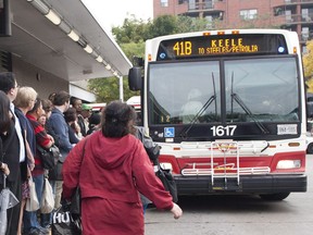 Crowds of people line up to ride shuttle buses going westbound at Keele Station in Toronto.