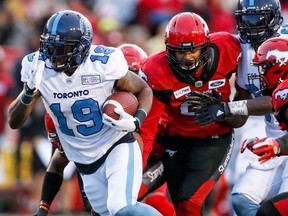 Toronto Argonauts' S.J. Green, left, makes it past Calgary Stampeders players during second half CFL football action in Calgary, Thursday, July 18, 2019.