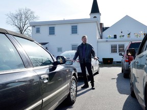 Pastor Aaron R. Goodro greets his parishioners in their cars during a drive-in Easter Service at the First Baptist Church in Plaistow, New Hampshire on April 12, 2020.