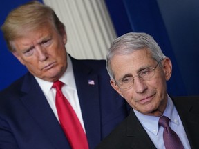Director of the National Institute of Allergy and Infectious Diseases Anthony Fauci, flanked by US President Donald Trump, speaks during the daily briefing on the novel coronavirus, which causes COVID-19, in the Brady Briefing Room of the White House on April 22, 2020, in Washington, DC.