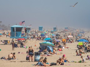 In this file photo taken on April 25, 2020 people enjoy the beach amid the novel coronavirus pandemic in Huntington Beach, California.