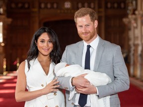 Prince Harry, Duke of Sussex and Meghan, Duchess of Sussex, pose with their newborn son Archie Harrison Mountbatten-Windsor during a photocall in St George's Hall at Windsor Castle on May 8, 2019 in Windsor, England.