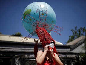 Artist Kong Ning, wearing a face mask as protection against COVID-19, adjusts a wearable art piece she made to mark Earth Day, in Beijing, China, on April 22, 2020.