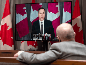 Finance Minister Bill Morneau appears on a television as he participates in a daily COVID-19 news conference via videoconference in Ottawa, April 17, 2020.