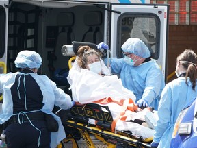 A woman arrives by ambulance to Wyckoff Hospital in the Bushwick section of Brooklyn April 5, 2020 in New York.