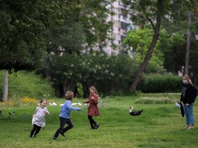 Children run under the eye of her mother as they play in a park on April 26, 2020 amid a national lockdown to prevent the spread of the COVID-19 disease.