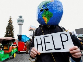 A man demonstrates as Greenpeace stages a climate protest at Amsterdam Schiphol Airport in Netherlands on Dec. 14, 2019.