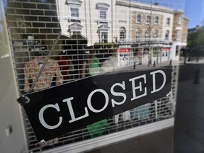 A closed sign is seen on the front of a closed clothing store in London on April 14, 2020, as Britain continues to enforce a lockdown aimed at slowing the spread of COVID-19.