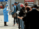 People wait in line to b0e tested for COVID-19 outside Roseland Community Hospital in Chicago, Illinois, April 7, 2020.