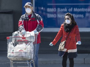 A couple wearing masks leave Markham’s Denison Centre with groceries during the ongoing  pandemic, Wednesday April 1, 2020.