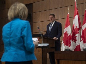 Leader of the Official Opposition Andrew Scheer listens as a (physically distanced) reporter asks a question during a news conference in Ottawa, Tuesday April 14, 2020.