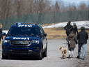 A police car drives down a path on Mount Royal in Montreal to ensure people keep a distance from each other on the weekend.