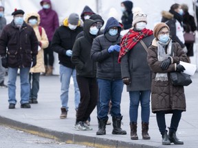 People line up outside a walk-in COVID-19 test clinic in Montreal on Monday, March 23, 2020.