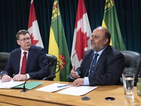 Saqib Shahab, chief medical health officer, right, speaks while Scott Moe, Premier of Saskatchewan, looks on at a COVID-19 news update at the Legislative Building in Regina on Wednesday March 18, 2020. Saskatchewan has released its five-phase plan to reopen the province.