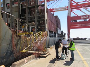 Mission to Seafarers volunteer Joseph Loot, right, delivering provisions and SIM cards to crew aboard the container ship Hansa Meersburg in Halifax on Sunday April 5, 2020.