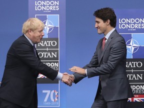 British Prime Minister Boris Johnson, left, welcomes Canadian Prime Minister Justin Trudeau during official arrivals for a NATO leaders meeting at The Grove hotel and resort in Watford, Hertfordshire, England, Wednesday, Dec. 4, 2019. Britain's envoy to Canada says Prime Minister Boris Johnson is a fighter who has what it takes to recover from his COVID-19 affliction.
