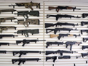 In this Oct. 2, 2018, semi-automatic rifles fill a wall at a gun shop in Lynnwood, Wash. Starting Tuesday, Jan. 1, 2019. The federal government is poised to ban a variety of assault-style rifles.