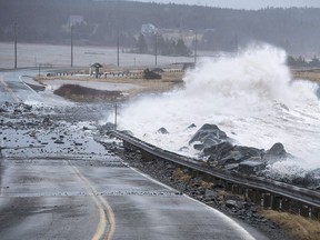 Waves pound the shore on a closed section of Highway 207 in Lawrencetown, N.S. on Friday, Jan. 5, 2018. A new analysis of flood risk suggests the yearly bills from overflowing rivers and rising seas could nearly triple by 2030, if Canada doesn't do more to improve flood protection.