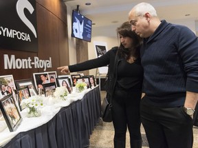 People pause at a memorial prior to a ceremony in Montreal, Sunday, Jan. 19, 2020, to remember those who lost their lives in Ukraine International Airlines Flight 752 which was shot down shortly after takeoff in Iran on January 8, 2020. Canada and Ukraine flatly rejected a report out of Iran that suggested the regime was seeking immunity from future legal action in its January shootdown of a Ukrainian passenger plane that killed everyone on board.
