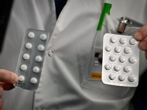 In this file photo taken on February 26, 2020, medical staff shows o at the IHU Mediterranee Infection Institute in Marseille, packets of a Nivaquine, tablets containing chloroquine and Plaqueril, tablets containing hydroxychloroquine, drugs that has shown signs of effectiveness against coronavirus