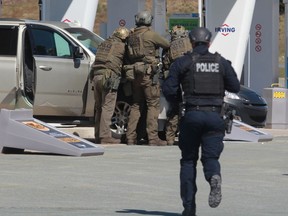 RCMP officers confront a shooting suspect at a gas station in Enfield, N.S. on April 19, 2020.