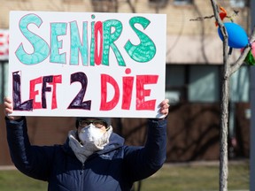 A person holds a sign outside Residence Herron, a senior's long-term care facility, following a number of deaths since the coronavirus disease (COVID-19) outbreak, in the suburb of Dorval in Montreal, April 11, 2020.