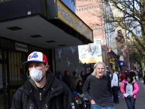 Residents of Vancouver's Downtown Eastside wait to collect social assistance cheques, on March 25.