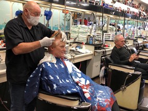 Barber Tommy Thomas, 69, who has been cutting hair for 50 years, gives his long-time customer Fred Bentley a haircut after the Georgia governor allowed a select number of businesses to open during the coronavirus disease (COVID-19) restrictions in Atlanta, Georgia, U.S. April 24, 2020.
